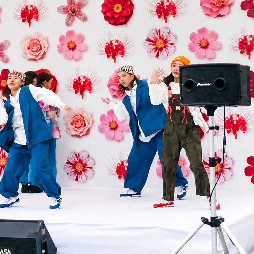 2025年のステージ。花の装飾を背景に踊るダンサーたち